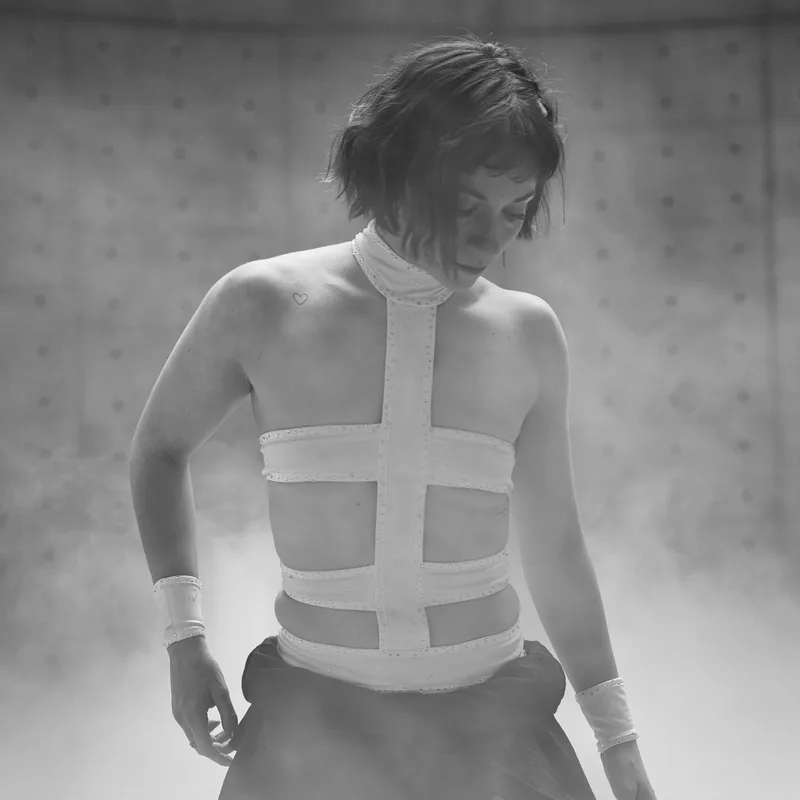 Danseuse ajustant sa tenue dans la fumée entre deux prises, direction sur place par HENLAW Paris